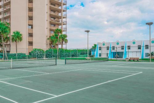 a tennis court in front of a building at GetAways at Turtle Reef Club in Jensen Beach
