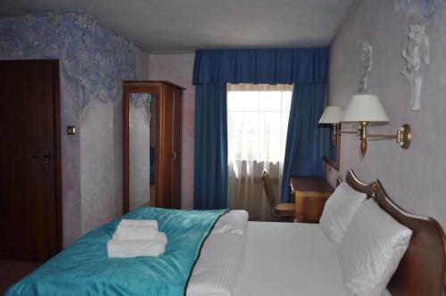a bedroom with a bed with towels on it at Hotel Księcia Józefa in Poznań