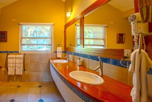 a yellow bathroom with two sinks and a mirror at Velero Beach Resort in Cabarete