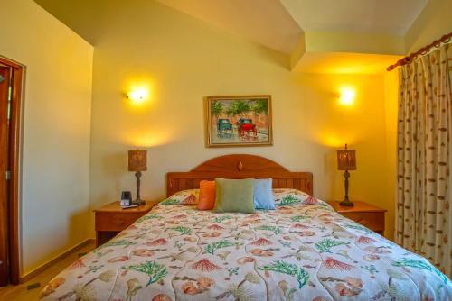 a bedroom with a bed and two night stands and two lamps at Velero Beach Resort in Cabarete