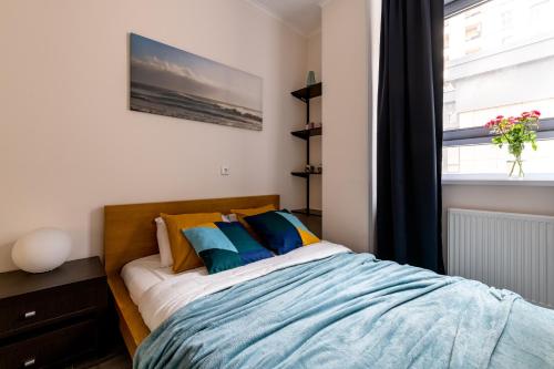 1 dormitorio con cama con almohadas y ventana en Rentalspb Apartment Graf Orlov en San Petersburgo