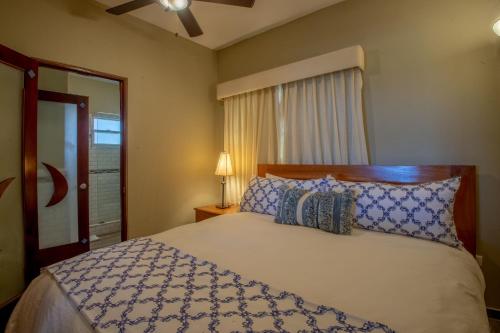 a bedroom with a bed with blue and white pillows at Velero Beach Resort in Cabarete
