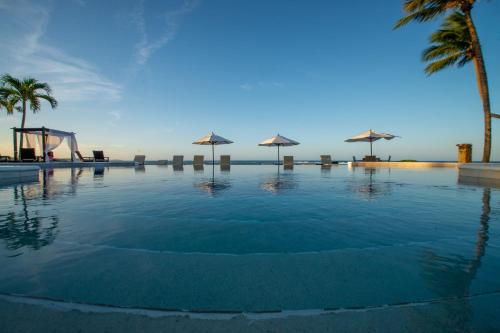 a large swimming pool with palm trees and a playground at Velero Beach Resort in Cabarete