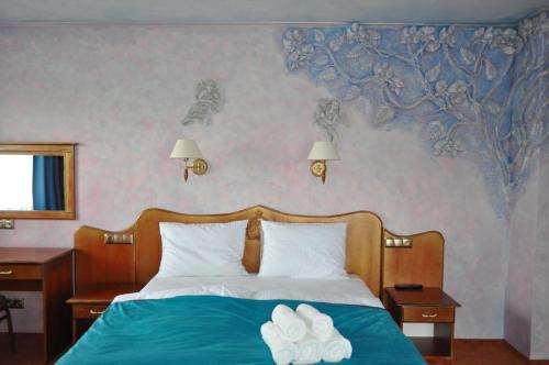 a bedroom with a bed with two towels on it at Hotel Księcia Józefa in Poznań