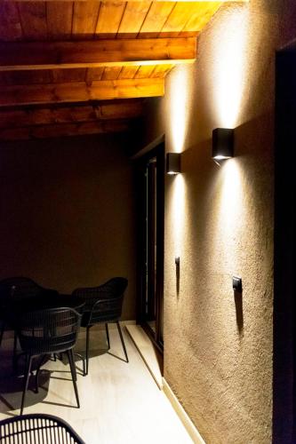 a room with chairs and tables on a wall at 19.40 Luxury Guesthouse in Kalpákion