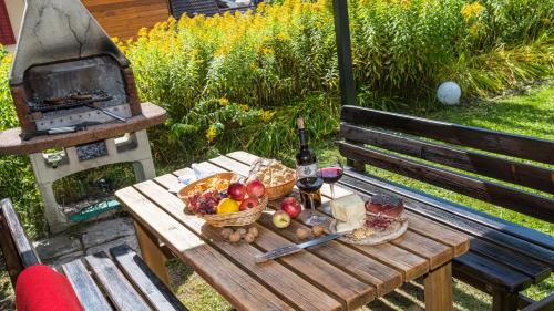 a picnic table with a basket of fruit and a grill at AppartChalet LA RONDULA - 100m from Seceda in Ortisei