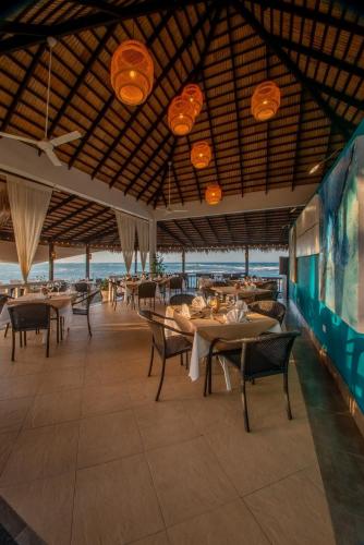 a restaurant with tables and chairs and a view of the ocean at Velero Beach Resort in Cabarete