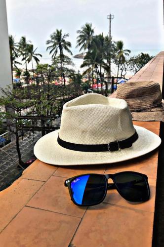 een hoed en zonnebril op een tafel bij Apartamento frente ao mar Pitangueiras in Guarujá