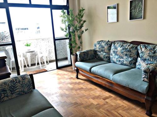 a living room with a couch and a table at Apartamento frente ao mar Pitangueiras in Guarujá