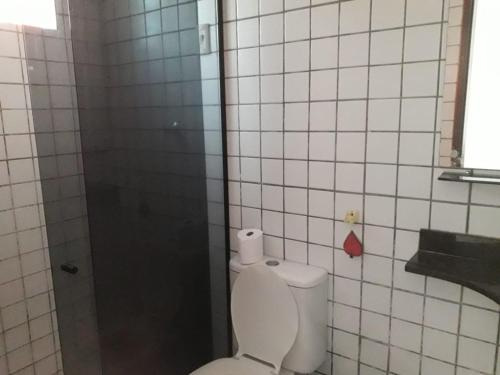 a bathroom with a white toilet and a shower at Residencial Ponta Negra Flat in Natal