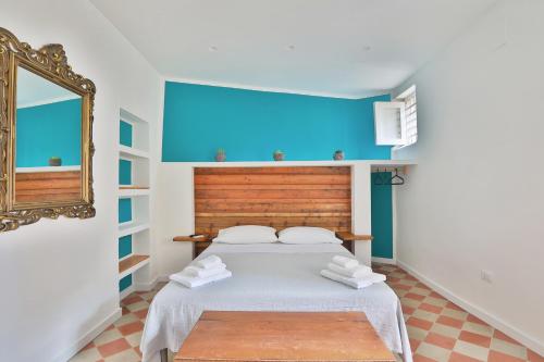 1 dormitorio con 1 cama con pared azul en Storie di Palermo, en Palermo