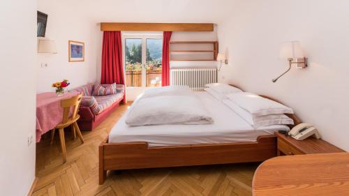 a bedroom with a bed and a table with a phone at AppartChalet LA RONDULA - 100m from Seceda in Ortisei