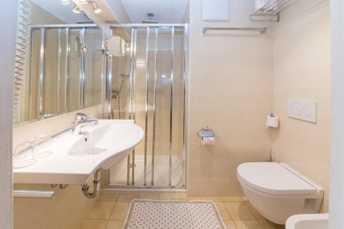 a bathroom with a sink and a toilet and a shower at AppartChalet LA RONDULA - 100m from Seceda in Ortisei