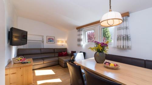 a living room with a couch and a table at AppartChalet LA RONDULA - 100m from Seceda in Ortisei