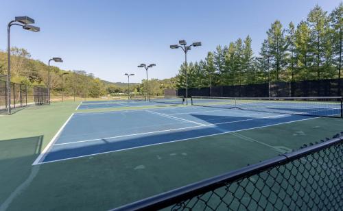 a tennis court with two tennis courts at Puttin on the Green Villa in Branson West