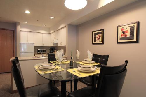 a dining room with a glass table and chairs at Lake Placid Lodge by Whistler Retreats in Whistler