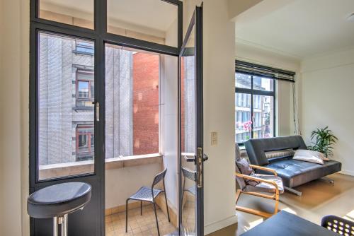 a living room with a door and a couch at The Meir Lodge. Apartments in heart of Antwerp in Antwerp