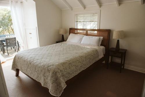 a bedroom with a bed and a window at Bow Street Apartments & Cottage in Raglan