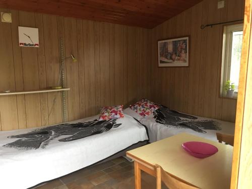 a room with two beds and a table and a window at ET-Home in Kungsbacka