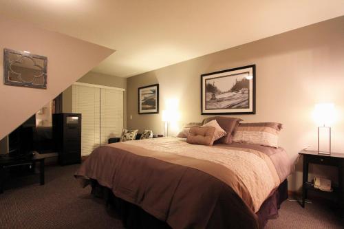 1 dormitorio con 1 cama grande y 2 lámparas en Sunpath Condos by Whistler Retreats, en Whistler