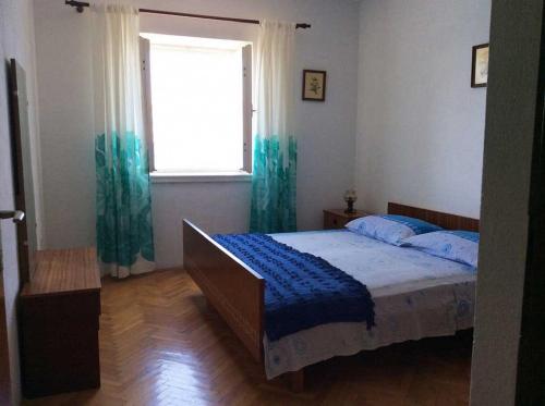 a bedroom with a bed and a window at Apartment Sova - 20m from beach in Postira