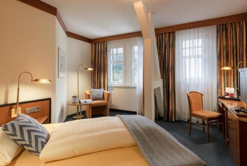 a hotel room with a bed and a desk at Hotel Neustädter Hof in Schwarzenberg (Erzgebirge)