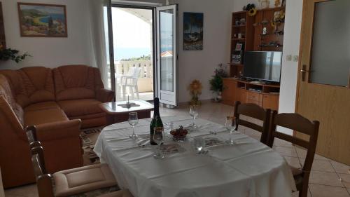a table with a bottle of wine on it in a living room at Apartment Juri - sea view in Postira