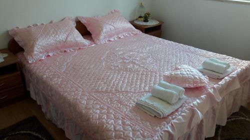 a pink bed with towels and pillows on it at Apartment Juri - sea view in Postira