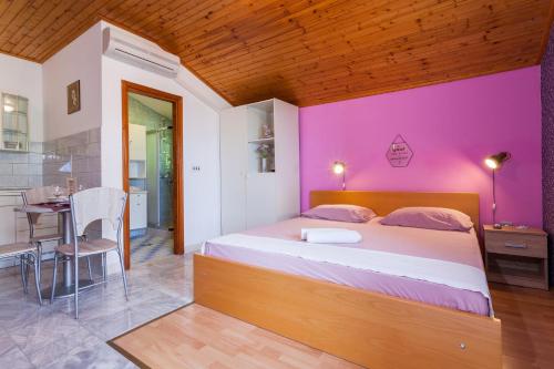 ein Schlafzimmer mit einem großen Bett mit einer rosa Wand in der Unterkunft Apartment Ante-50m from beach in Smokvica