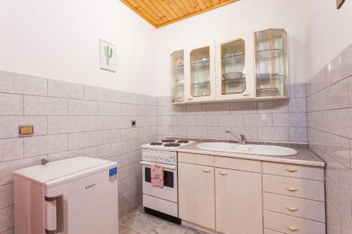 uma cozinha branca com um lavatório e um fogão em Apartment Ante-50m from beach em Smokvica