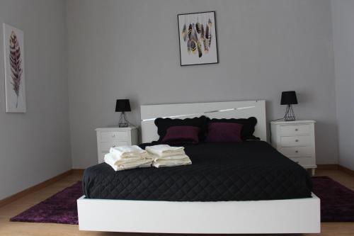 a bedroom with a black bed with two night stands at Viriato Central House in Viseu