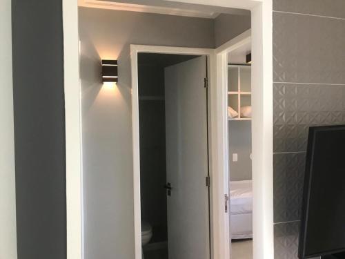 a hallway with a door to a bedroom with a light at Flat Beach Class Muro Alto 4307 in Porto De Galinhas