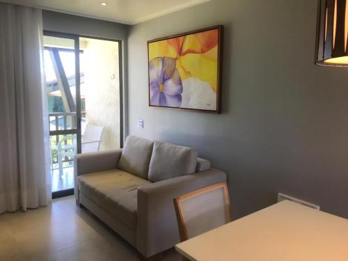 a living room with a couch and a painting on the wall at Flat Beach Class Muro Alto 4307 in Porto De Galinhas