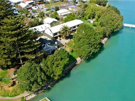an aerial view of a house on an island in the water at Bow Street Apartments & Cottage in Raglan