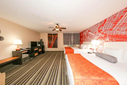 a hotel room with two beds and a desk at Howard Johnson by Wyndham Winnipeg West in Winnipeg