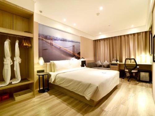 a bedroom with a large white bed and a desk at Atour Hotel Wuhan Changqing Road Branch in Wuhan