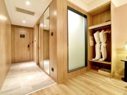 a room with a walk in closet with a large mirror at Atour Hotel Wuhan Changqing Road Branch in Wuhan