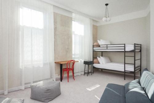 a living room with a bunk bed and a desk at Hotel Babula am Augarten in Vienna