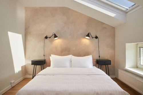 ein Schlafzimmer mit einem großen weißen Bett mit zwei Lampen in der Unterkunft Hotel Babula am Augarten in Wien