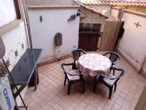 patio ze stołem i krzesłami oraz kuchnią w obiekcie B&B I Gigli w mieście Brusciano