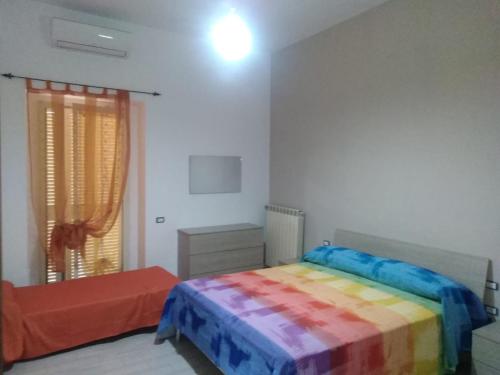 sypialnia z łóżkiem z kolorowym kocem w obiekcie B&B I Gigli w mieście Brusciano