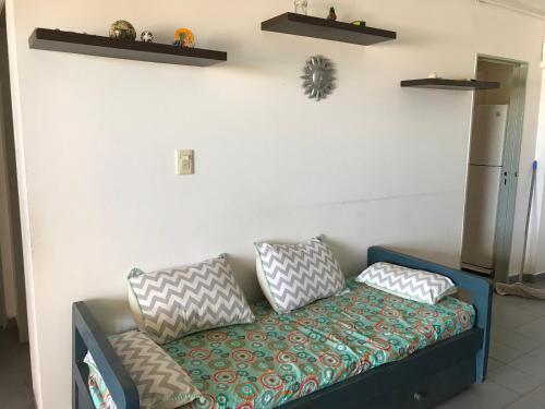 un sofá con almohadas en una habitación en el Departamento Libra XX ¡Ante el mar!  en Villa Gesell