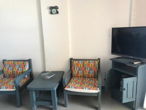 sala de estar con 2 sillas y TV en el Departamento Libra XX ¡Ante el mar!  en Villa Gesell