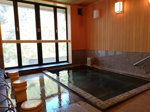 a room with a pool in the middle of a room at Hiranoya in Takayama