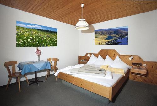 1 dormitorio con 1 cama, 1 mesa y 1 foto en Ferienhotel Sunshine, en Berg im Drautal