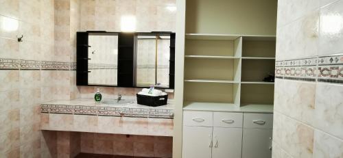 baño con lavabo, espejo y estanterías en Apartamento mediano ideal para parejas o ejecutivos, en Manta