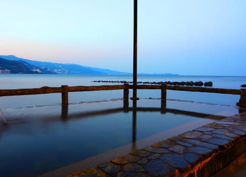 una vista de un cuerpo de agua con una valla en 熱海温泉 湯の宿 平鶴, en Atami