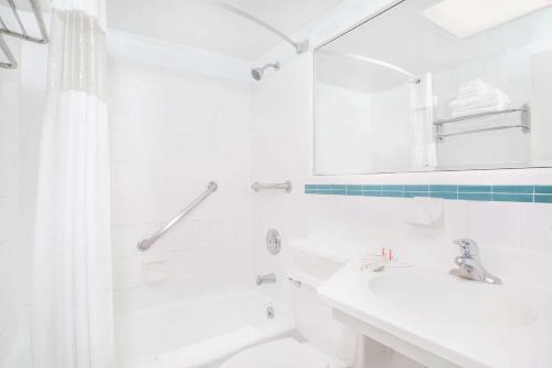 y baño blanco con lavabo y ducha. en Howard Johnson by Wyndham Atlantic City, en Atlantic City