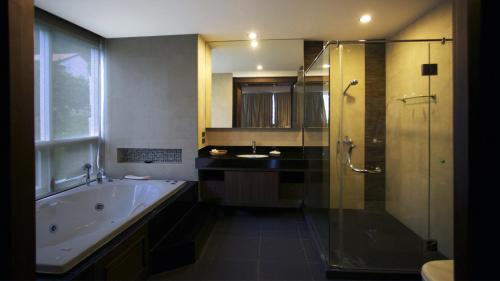 y baño con bañera, ducha y lavamanos. en Karon Suite Apartment, en Karon Beach