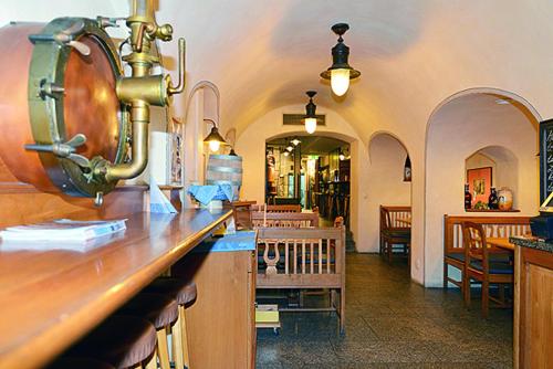 ein Restaurant mit einer Theke und eine Bar mit Stühlen in der Unterkunft Altstadthotel Bräuwirt in Weiden